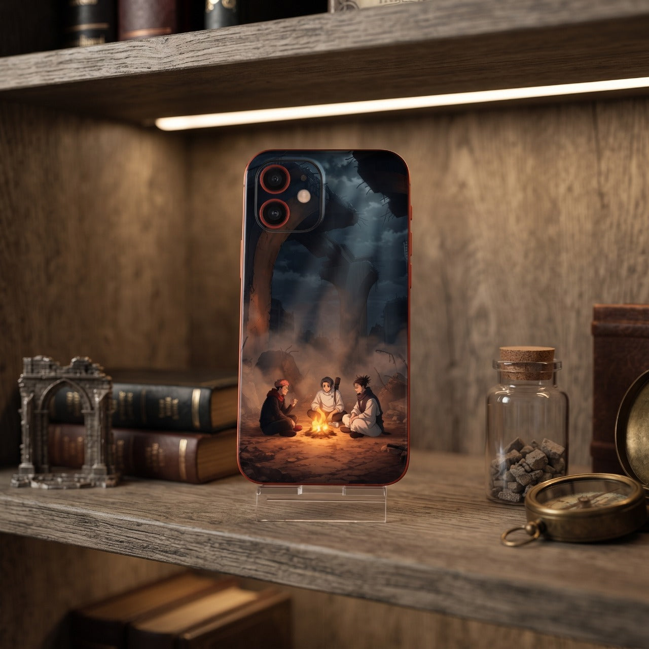 Coque iPhone Jujutsu Kaisen feu de camp posée sur une étagère avec une arche en ruine miniature et une boussole