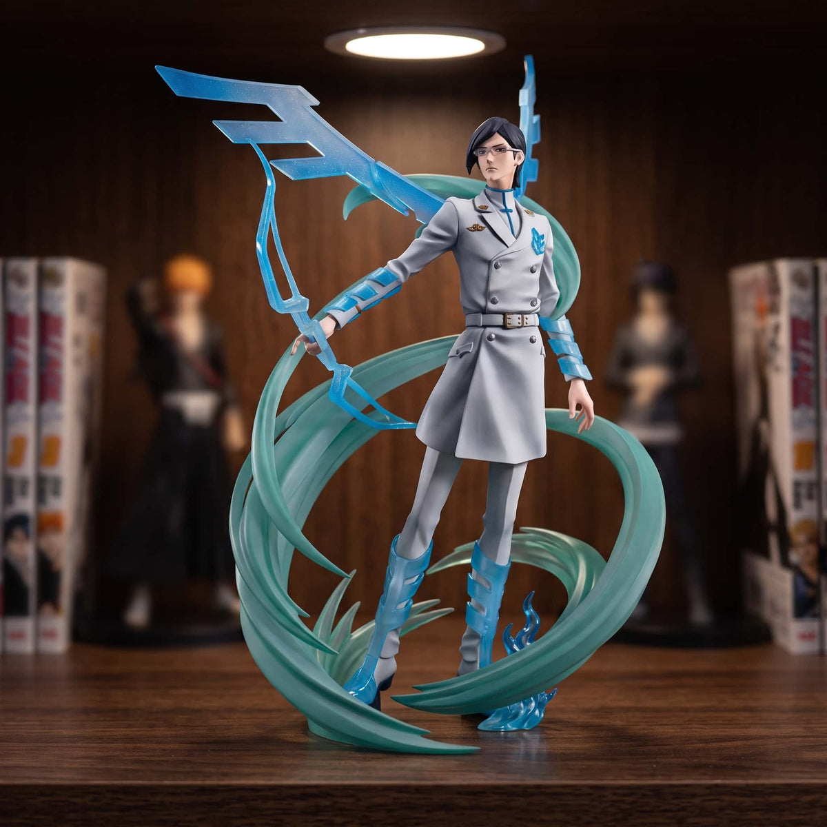 Figurine d'Uryū Ishida de Bleach en uniforme blanc, arc d'énergie bleu translucide bandé et volutes turquoise en spirale, sur un socle de rochers, posée sur une étagère en bois