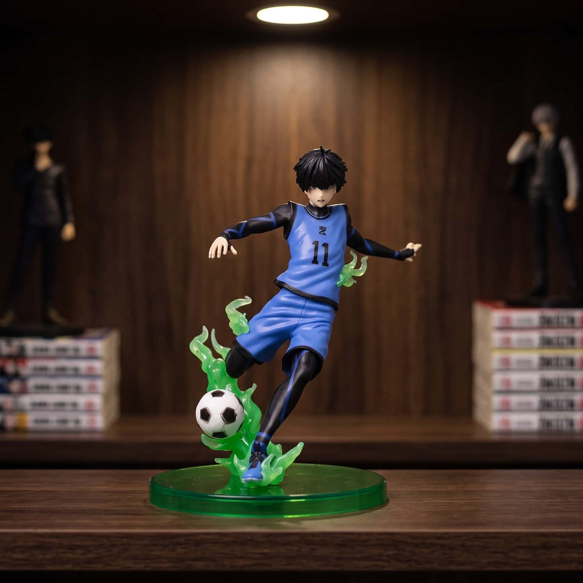 Figurine Isagi Yoichi (Blue Lock), 15,5 cm, en extension complète sur la frappe — posée sur une étagère en bois.