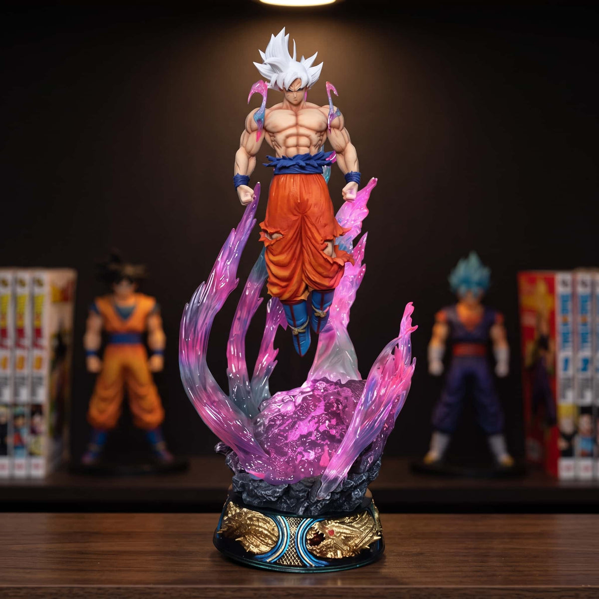 Figurine de Goku Ultra Instinct de 25 cm en lévitation dans une aura violette translucide, socle rond noir et or, posée sur une étagère en bois