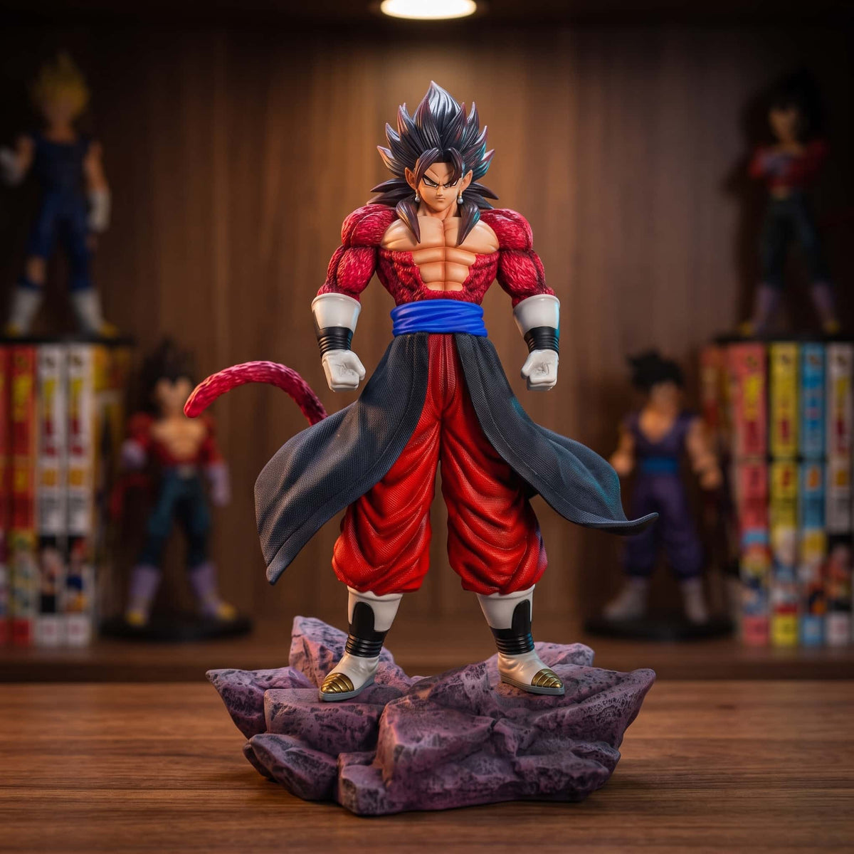 Figurine Vegito Super Saiyan 4 de 35 cm posée sur une étagère en bois sombre, fourrure rouge, ceinture bleue et long pan d'étoffe noire, socle de roche violette, tomes de manga en arrière-plan