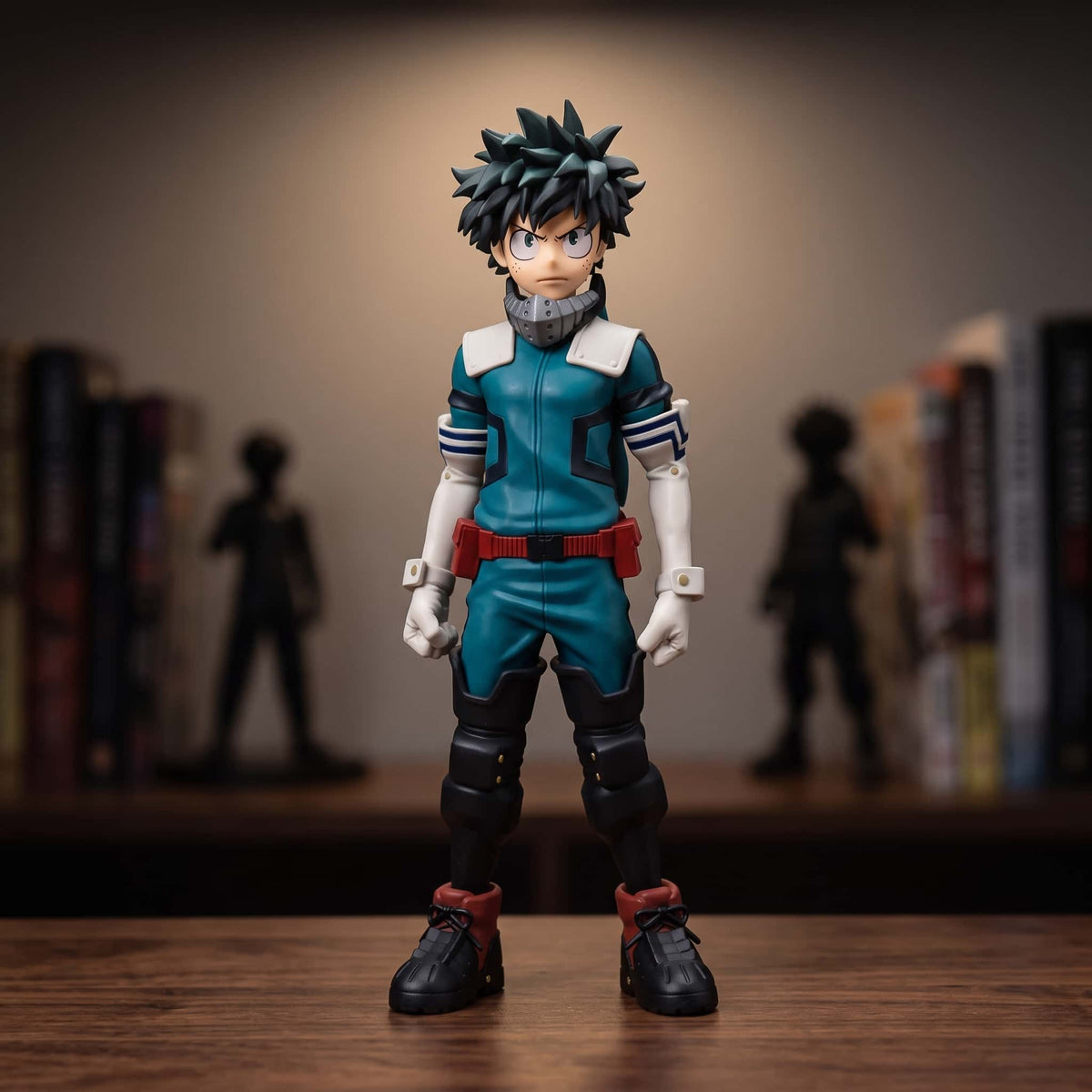 Figurine d'Izuku Midoriya debout en costume vert complet, col-masque blanc et ceinture rouge, 25 cm, poings serrés, posée sur une étagère en bois