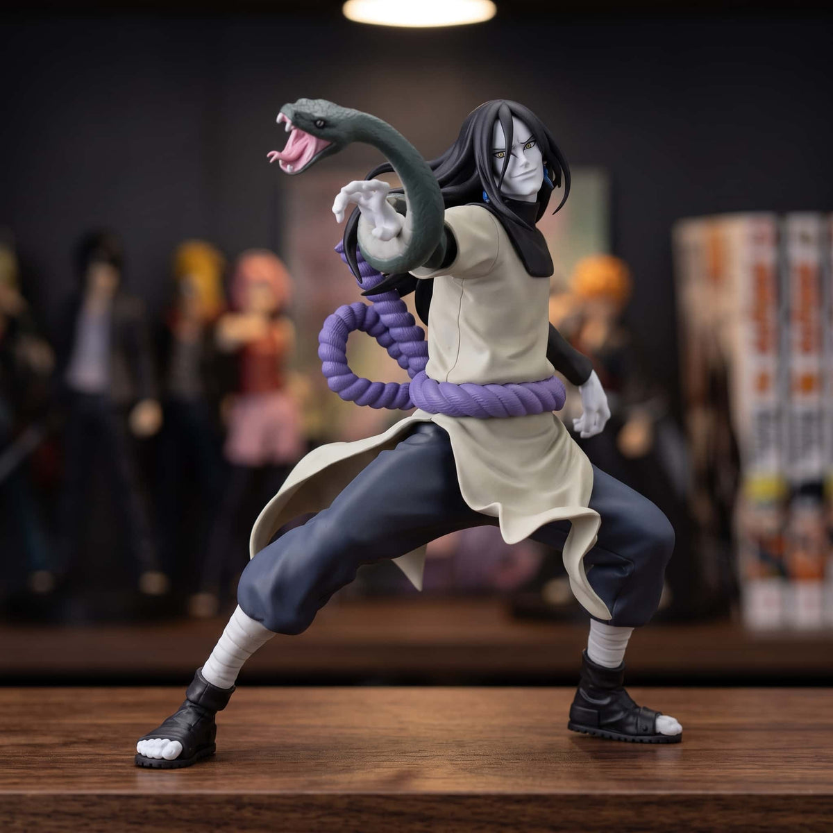 Figurine Naruto Orochimaru 16 cm en garde avec son serpent, exposée sur une étagère devant des figurines (décor non inclus)