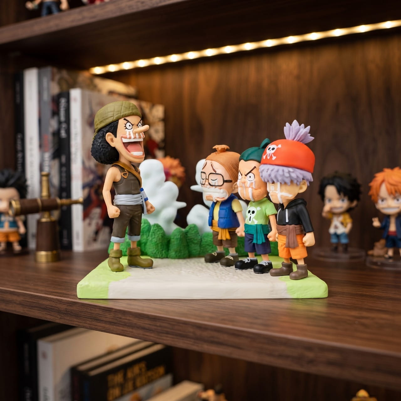 Diorama One Piece Usopp faisant ses adieux aux trois Usopp Pirates, exposé sur une étagère (décor non inclus)