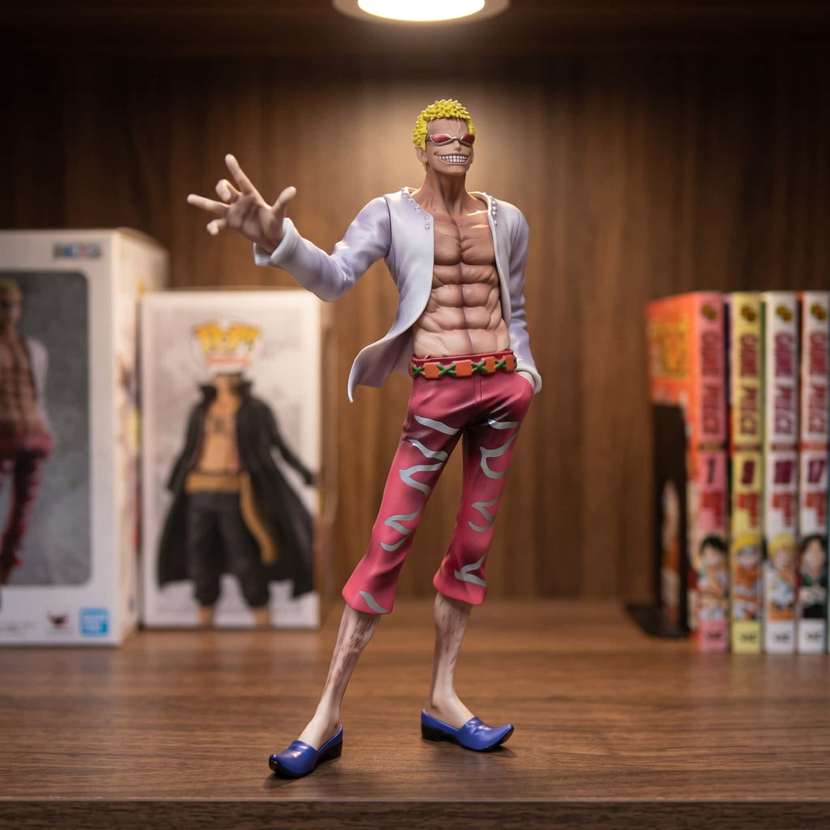 Figurine One Piece Donquixote Doflamingo 29 cm debout en chemise ouverte, exposée sur une étagère (décor non inclus)