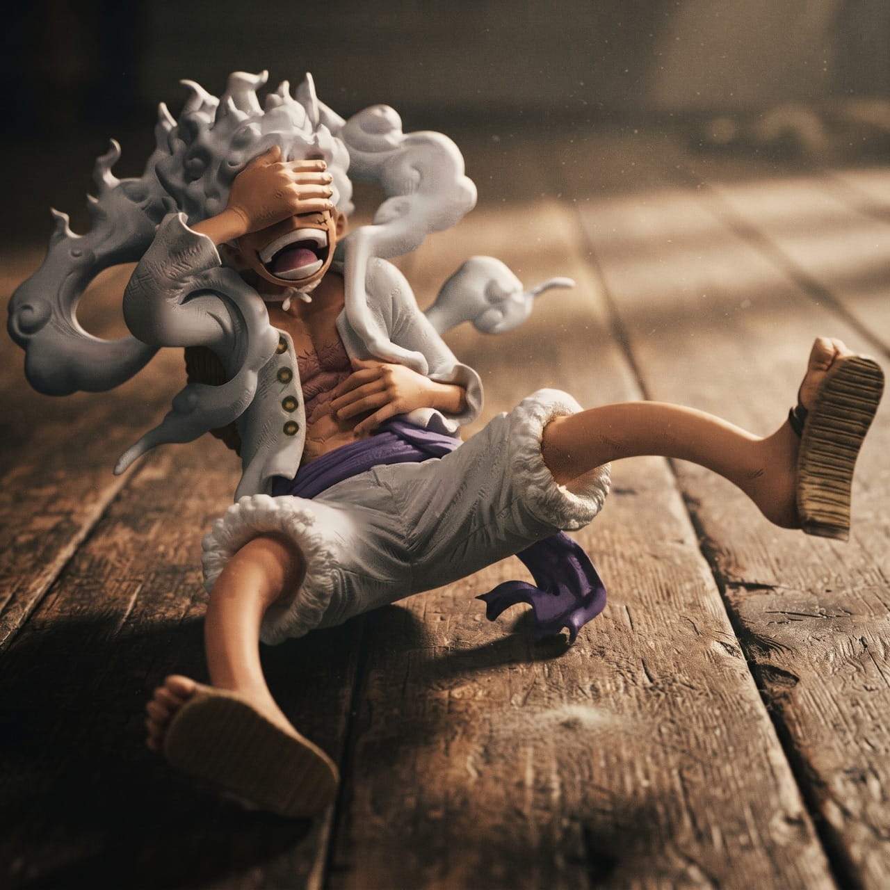 Figurine Luffy Gear 5 riant, assis main sur l'œil, sur un plancher de bois chaud — One Piece