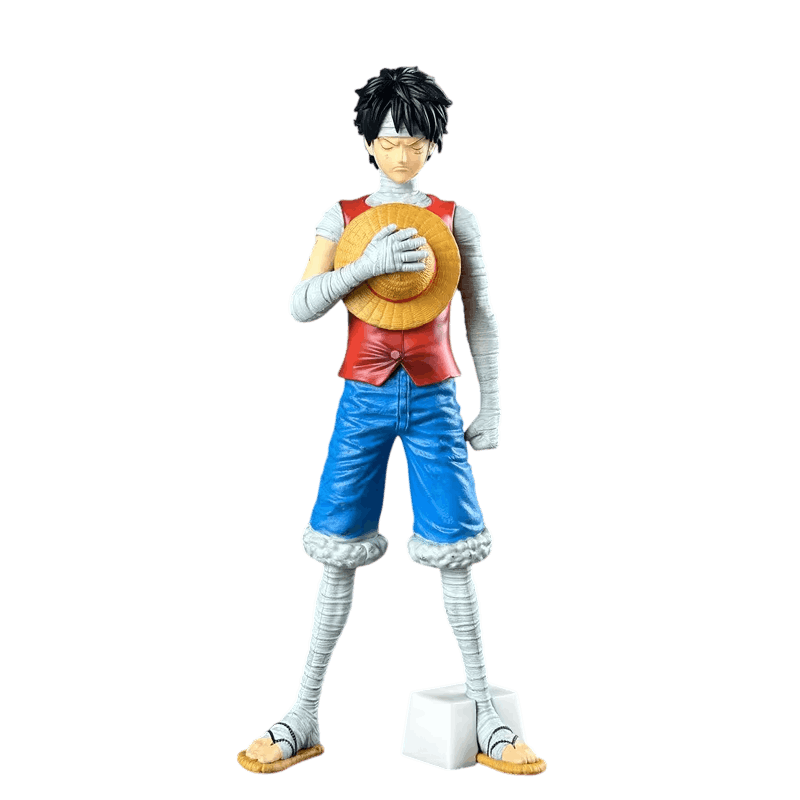 Figurine Luffy One Piece 28 cm couvert de bandages : yeux fermés, chapeau de paille serré contre la poitrine, gilet rouge, short bleu