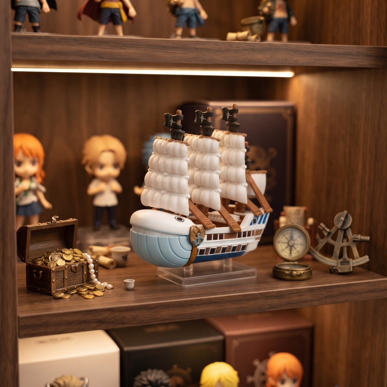 Réplique miniature du Moby Dick posée sur une étagère en bois, boussole et sextant anciens à côté — One Piece (décor non inclus)