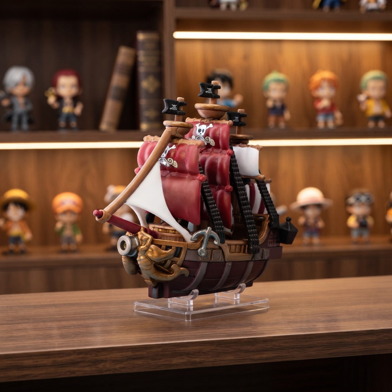 Réplique miniature de l'Oro Jackson posée sur un présentoir transparent devant une bibliothèque en bois — One Piece (décor non inclus)