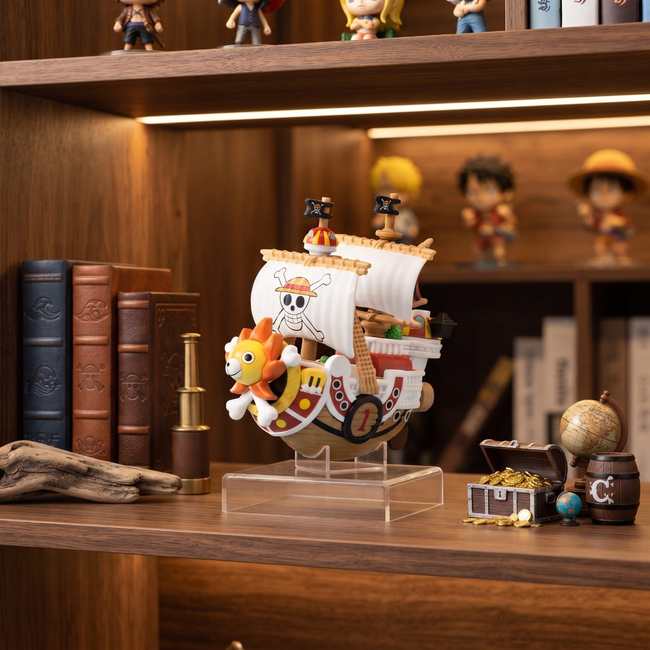 Réplique miniature du Thousand Sunny posée sur une étagère en bois, coffre au trésor et globe ancien à côté — One Piece (décor non inclus)