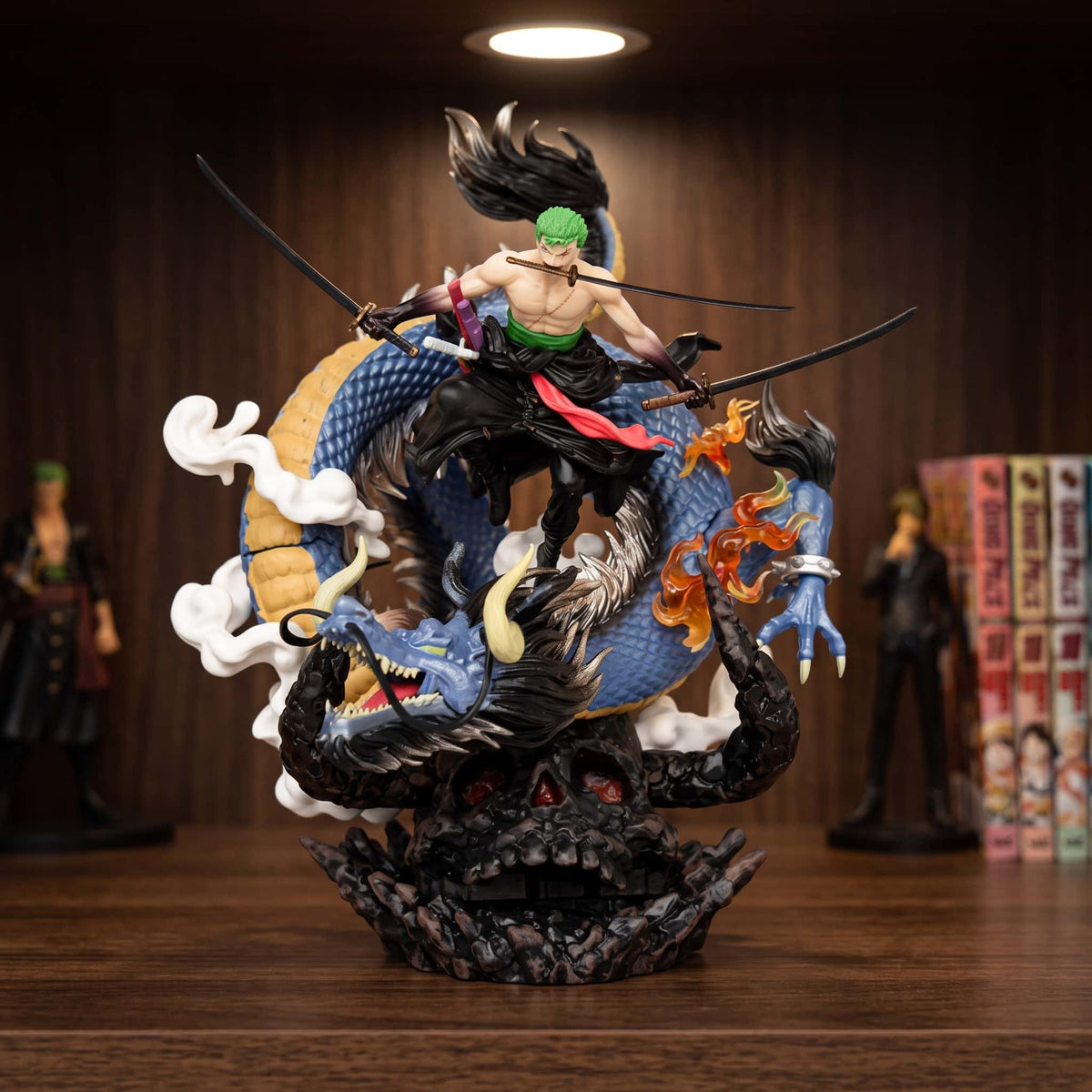 Figurine Roronoa Zoro et le dragon (One Piece), diorama en spirale : le sabreur au sommet, le dragon en dessous — posée sur une étagère en bois.