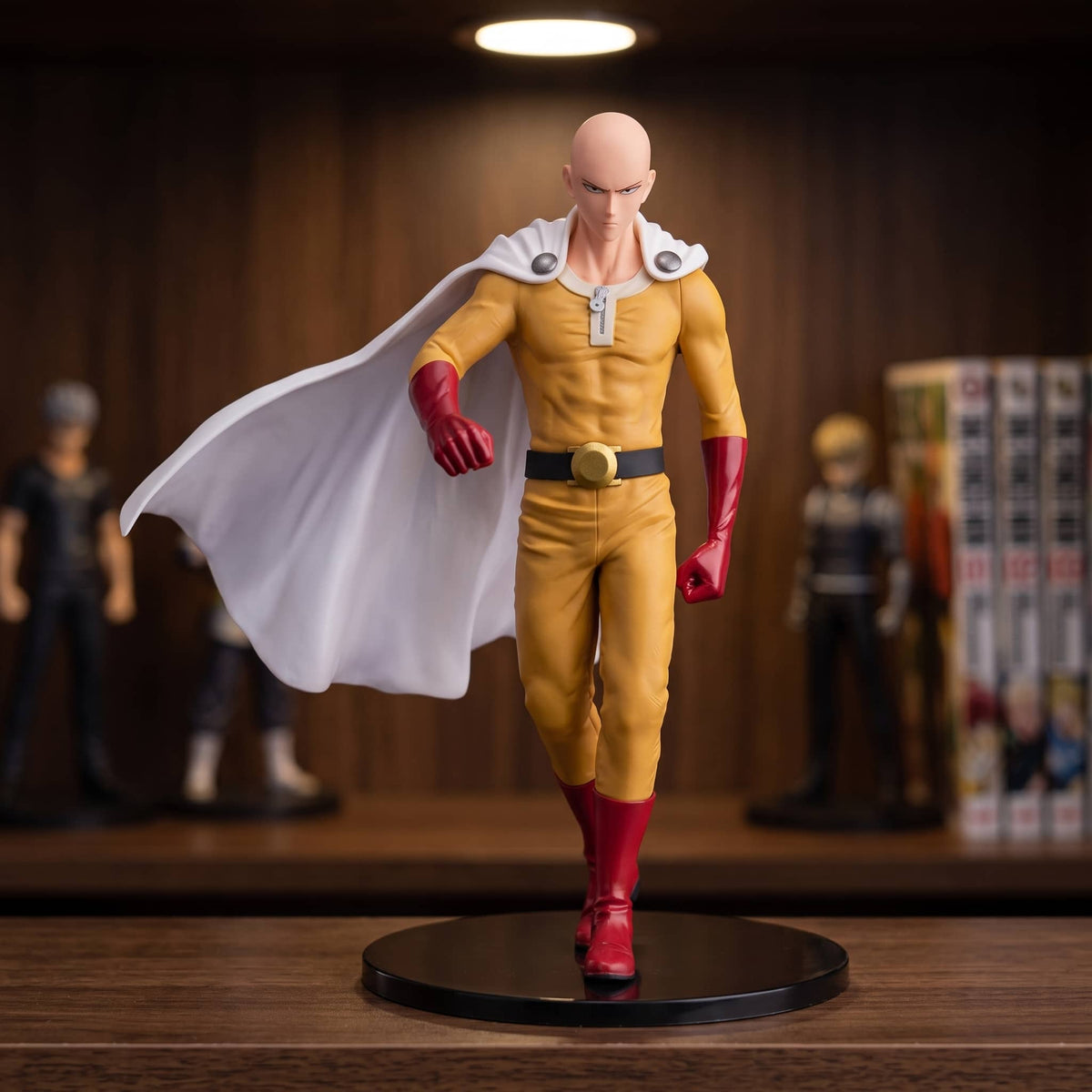 Figurine Saitama (One Punch Man), 17 cm, la pose canonique du personnage — posée sur une étagère en bois.