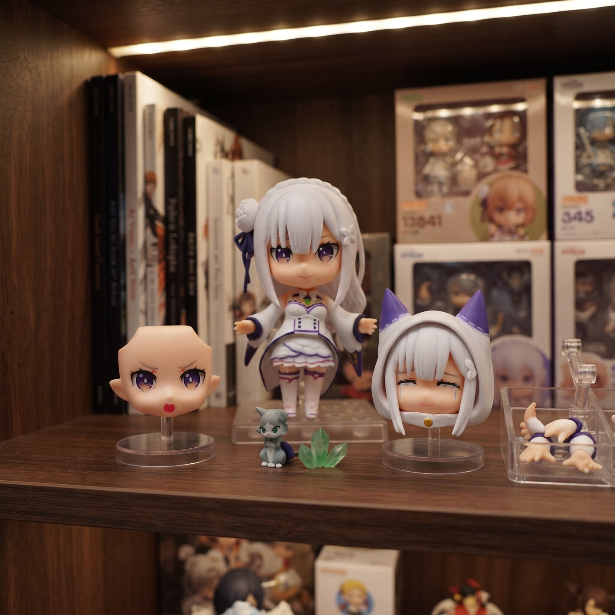 Figurine chibi Emilia de Re:Zero avec ses accessoires, exposée sur une étagère (décor non inclus)
