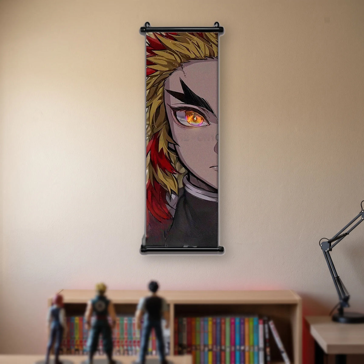 Kakémono Demon Slayer Kyojuro Rengoku en gros plan, cheveux de flammes et œil ambre, suspendu au mur beige d'une chambre au-dessus d'une étagère de tomes de manga