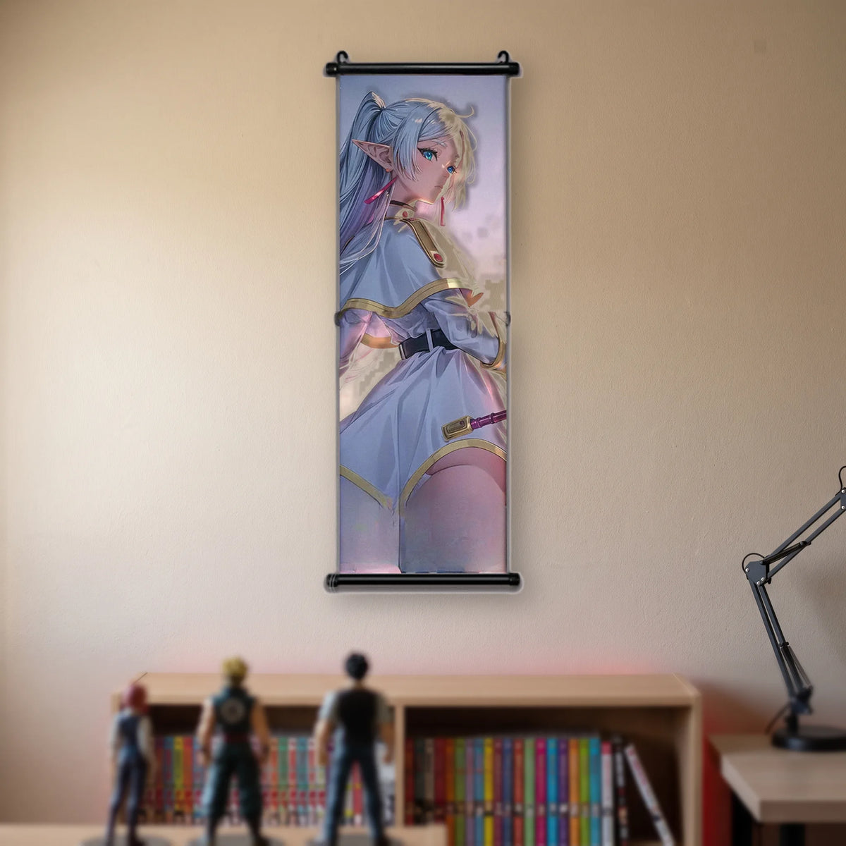 Kakémono Frieren, Frieren vue de dos, tournée vers l'épaule, sur un fond rose pâle, suspendu au mur beige d'une chambre au-dessus d'une étagère de tomes de manga
