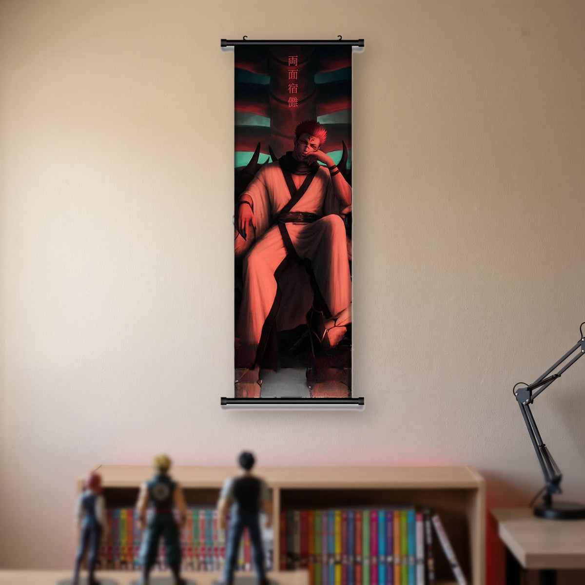 Kakémono Jujutsu Kaisen Sukuna assis en robe rouge devant un mur gravé, suspendu au mur beige d'une chambre au-dessus d'une étagère de tomes de manga et de figurines