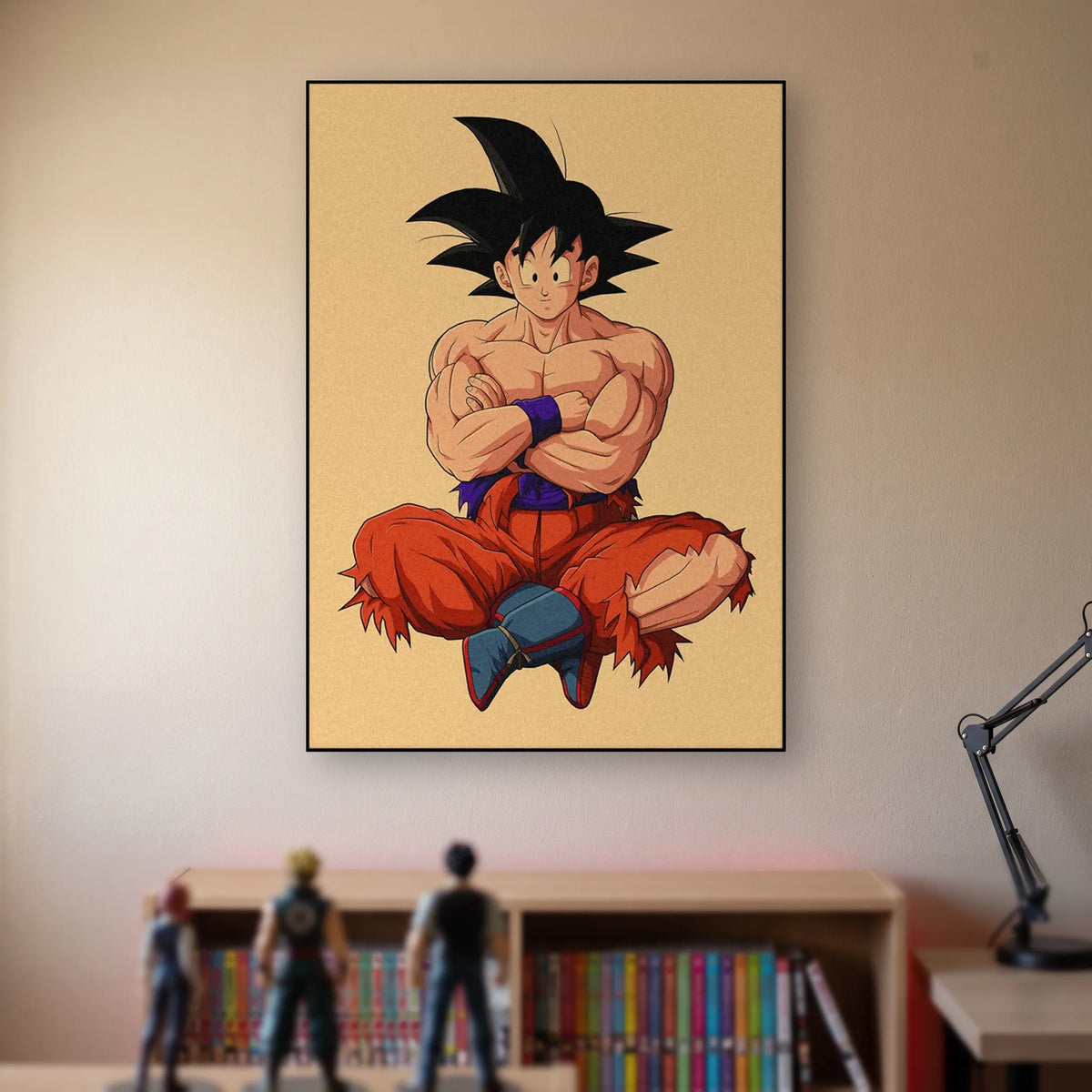 Poster Dragon Ball Son Goku — assis, bras croisés, accroché sans cadre sur le mur beige d'une chambre, au-dessus d'une étagère de tomes de manga et de figurines