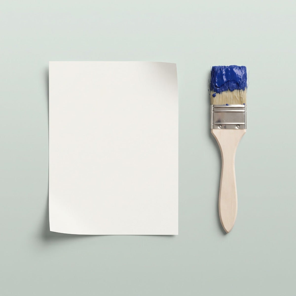 Toile vierge posée à plat à côté d'un pinceau chargé de peinture bleue, prête à recevoir ton image — poster personnalisé Manga Horizon