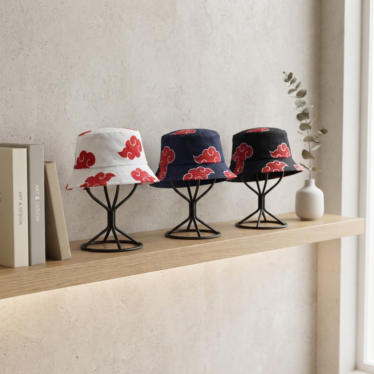 Trois bobs Naruto aux nuages rouges de l'Akatsuki, bleu marine, noir et blanc, posés sur des supports
