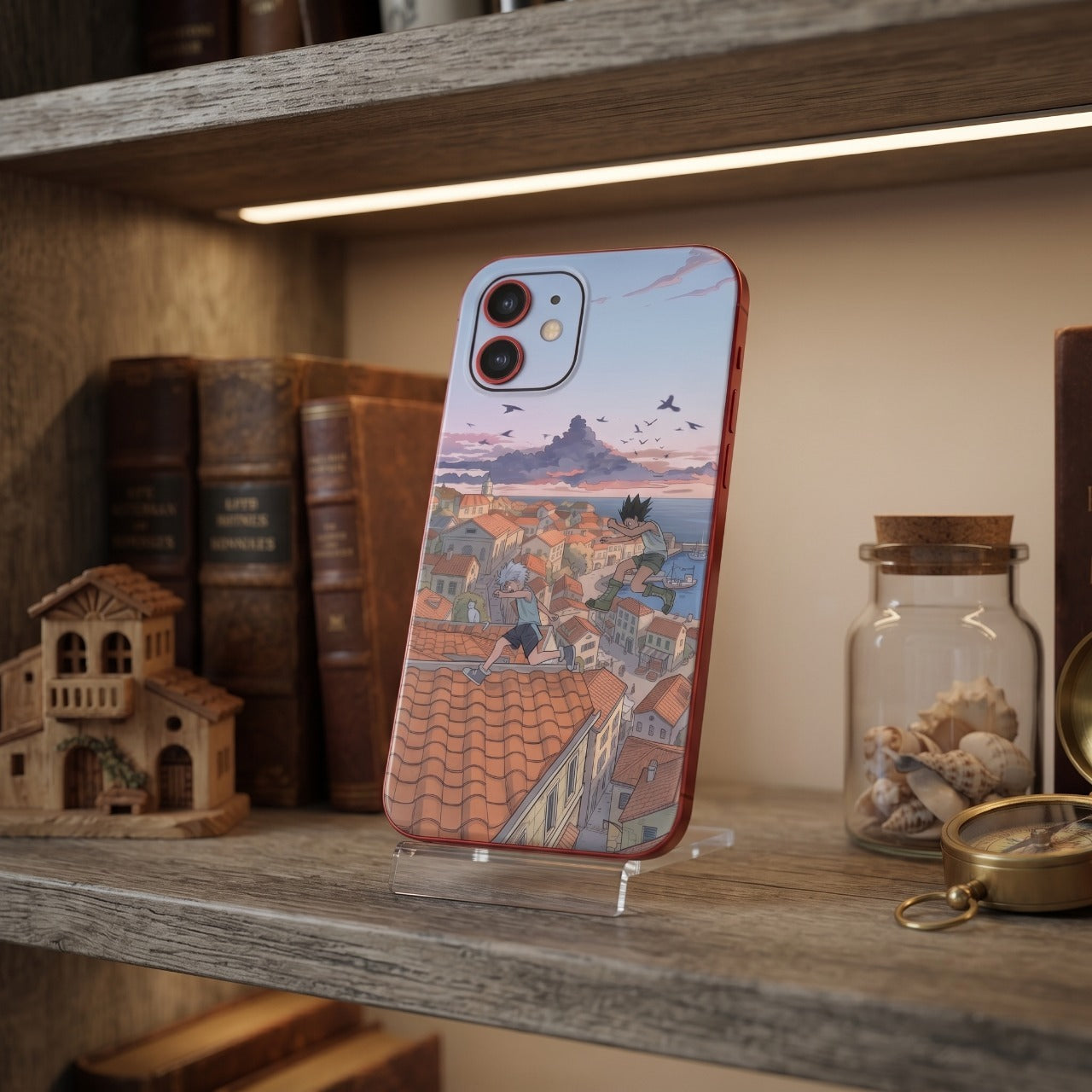 Coque iPhone Hunter x Hunter Gon et Killua posée sur une étagère en bois éclairée