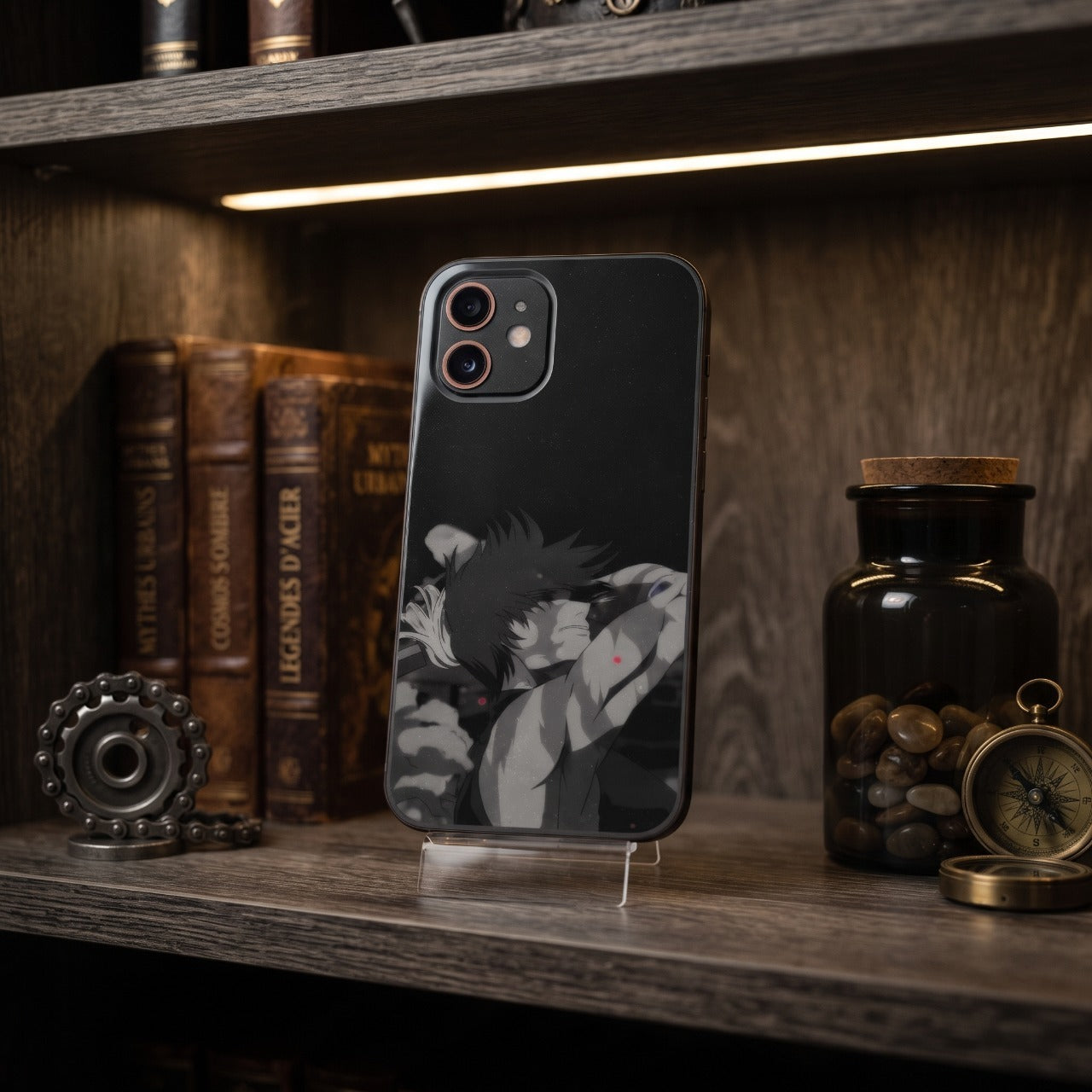 Coque iPhone Jujutsu Kaisen Maki Zenin sur un support, étagère en bois avec livres anciens, engrenage et boussole