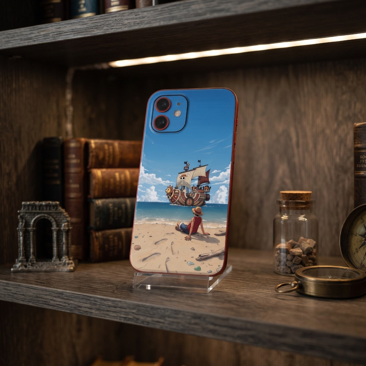 Coque iPhone One Piece Luffy et le Thousand Sunny posée sur une étagère en bois