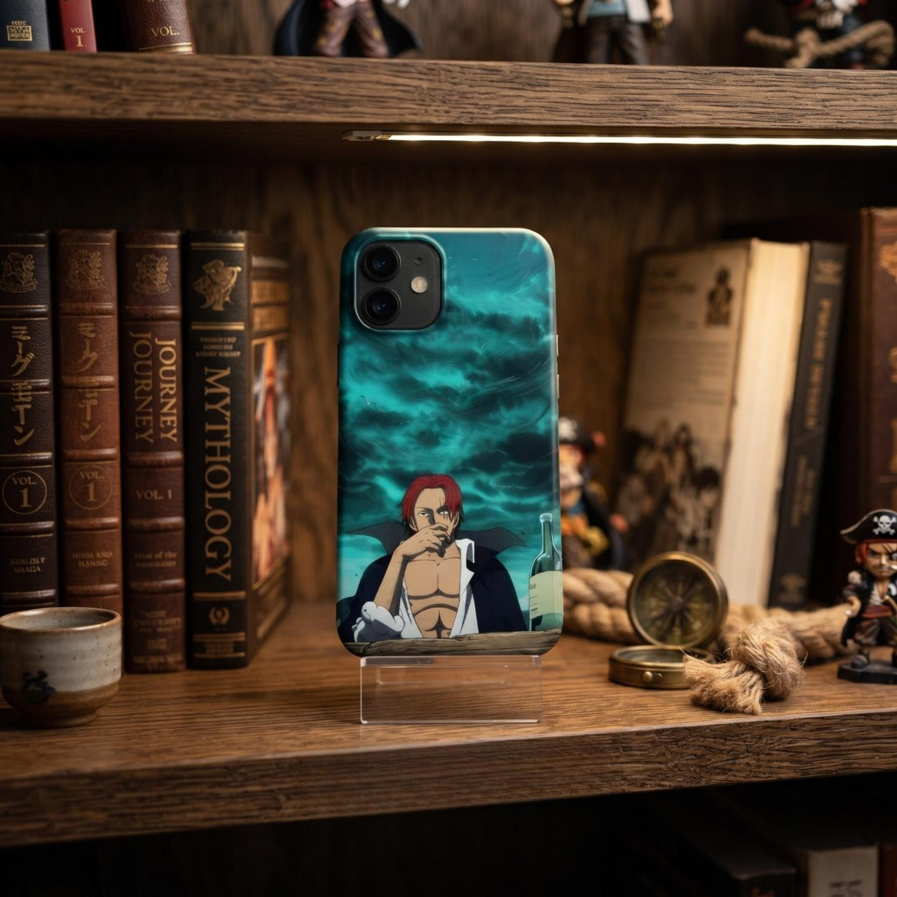 Coque iPhone One Piece Shanks le Roux sur fond turquoise, posée près d'une boussole et d'un cordage