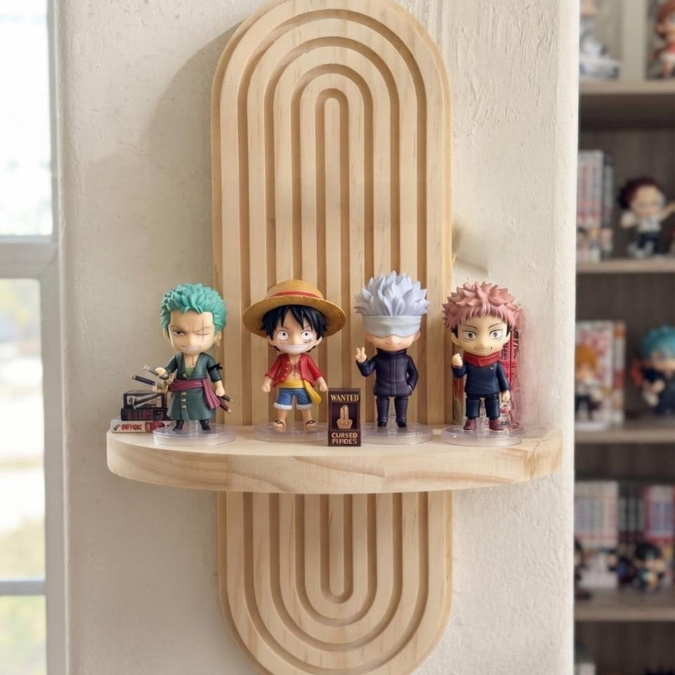 Étagère murale capsule en bois clair fixée sur un mur blanc, quatre figurines chibi alignées sur sa tablette centrale