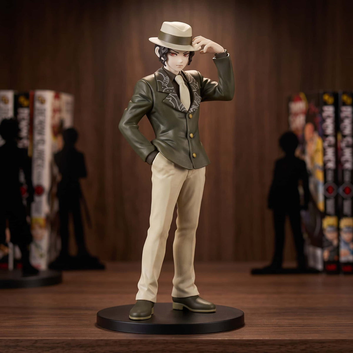 Figurine Demon Slayer Muzan Kibutsuji 17 cm en costume et chapeau, exposée sur une étagère devant des mangas (décor non inclus)