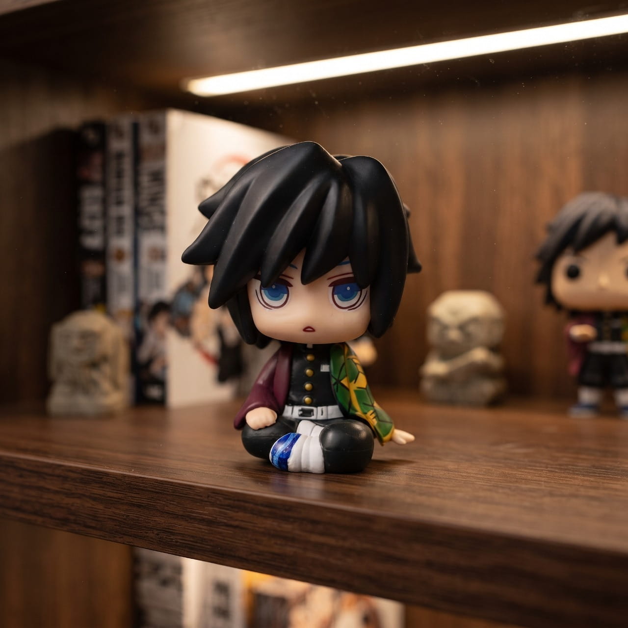 Figurine chibi Tomioka Giyu assis, exposée sur une étagère (décor non inclus)