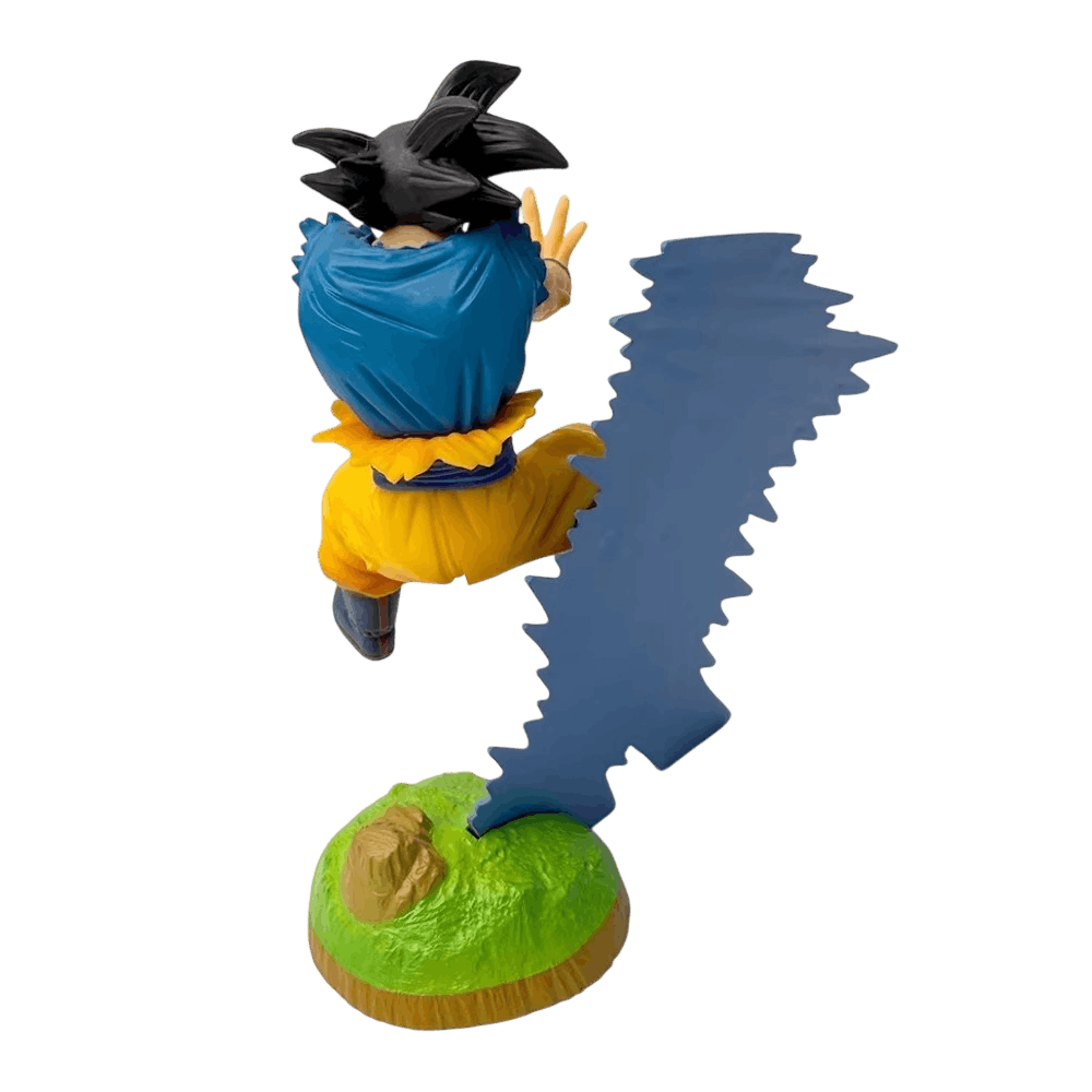 Figurine Goku Dragon Ball Z vue de dos et de haut : maillot bleu, tertre d'herbe et vague d'énergie bleue