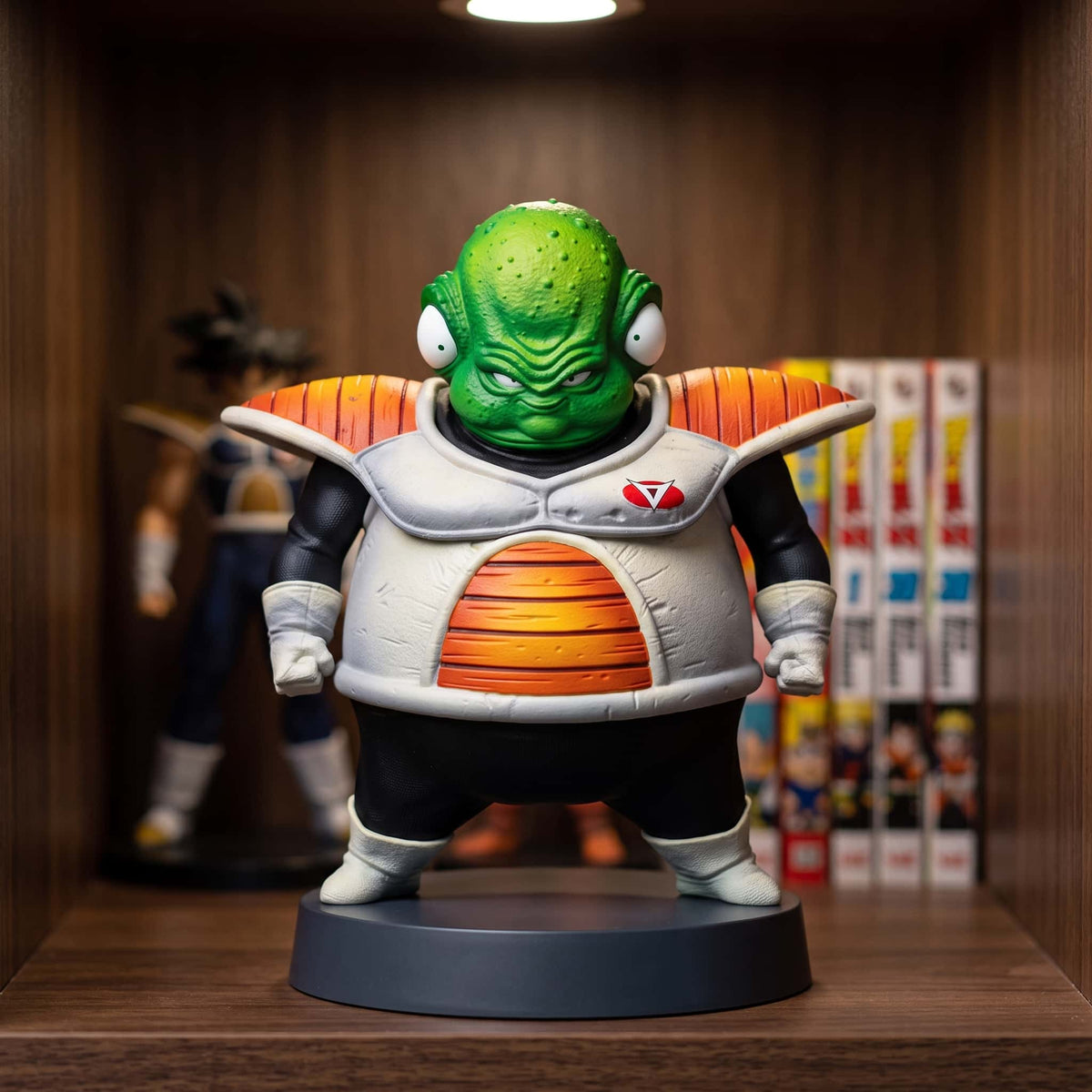 Figurine de Guldo du Commando Ginyu, 13 cm, peau verte et quatre yeux, armure blanche à épaulières, posée sur une étagère en bois sombre
