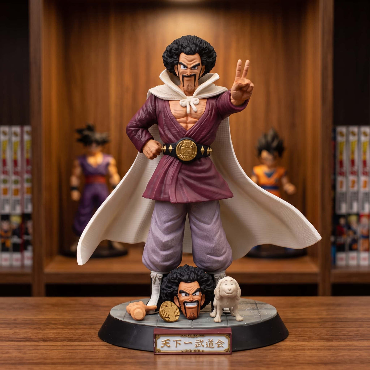 Figurine de Mr Satan de 23 cm, cape blanche déployée et deux doigts levés, ceinture de champion dorée, sur un socle du tournoi avec une tête de rechange, une médaille dorée et un petit chien blanc