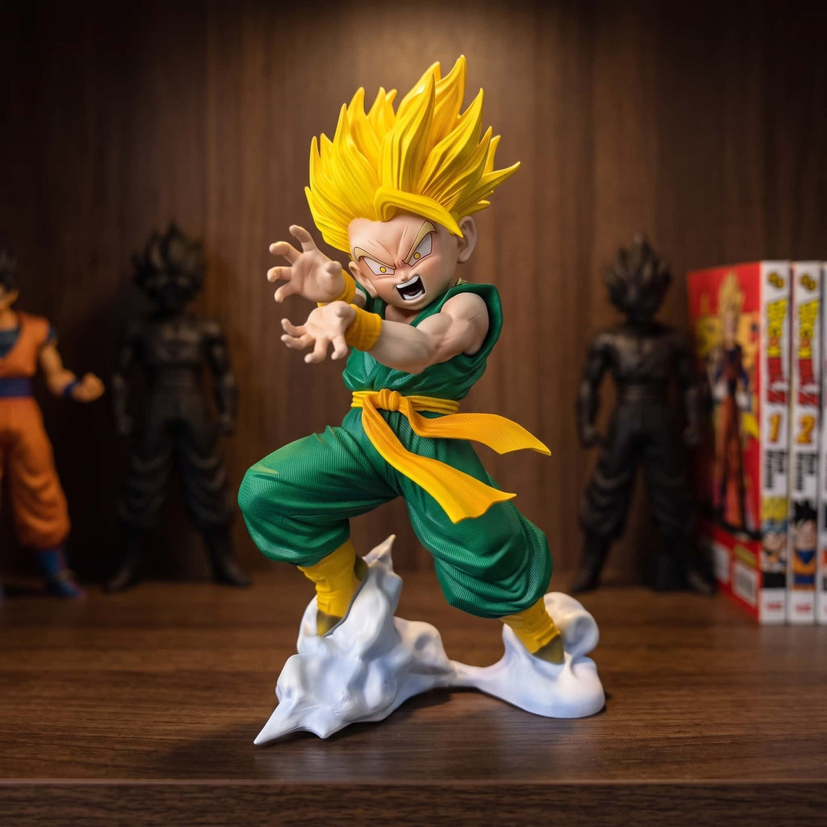 Figurine de Trunks enfant en Super Saiyan, 20 cm, garde relevée sur un socle de fumée blanche, gi vert et ceinture jaune, posée sur une étagère en bois