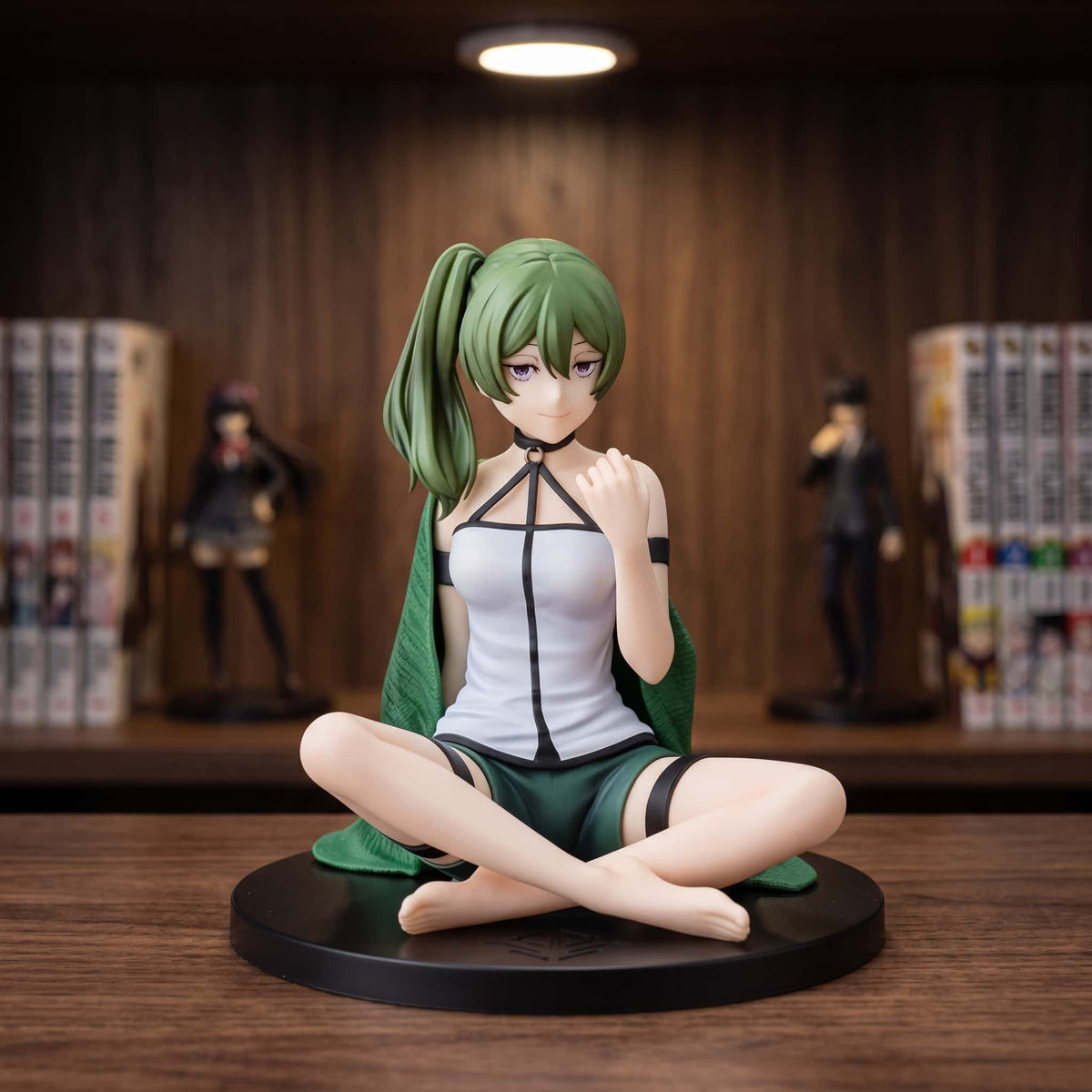 Figurine Frieren Übel 11 cm assise en tailleur en tenue d'intérieur, exposée sur une étagère (décor non inclus)