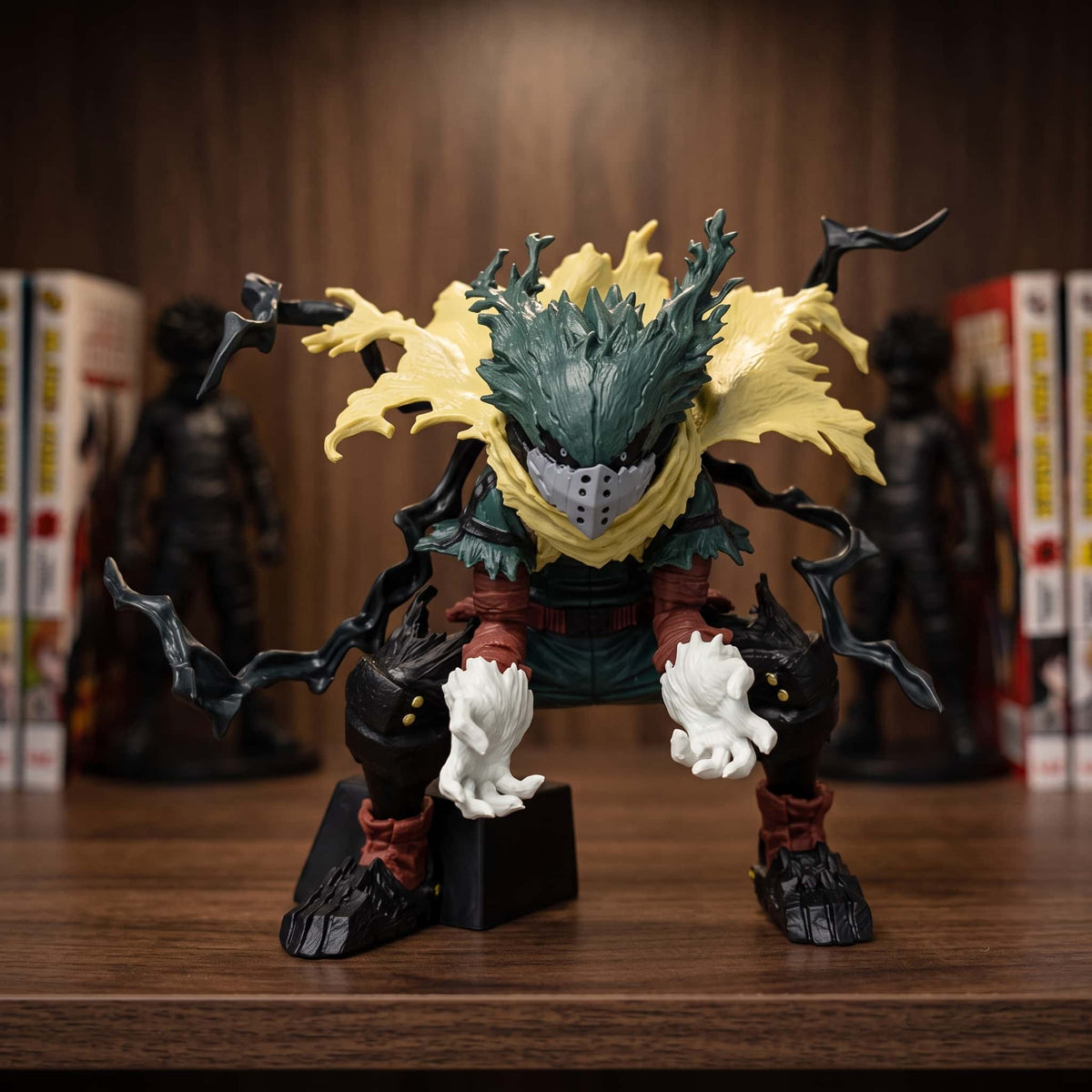 Figurine d'Izuku Midoriya ramassé au sol, longues arborescences noires du Fouet Noir jaillissant de ses bras, capuche verte, 11 cm, posée sur une étagère en bois