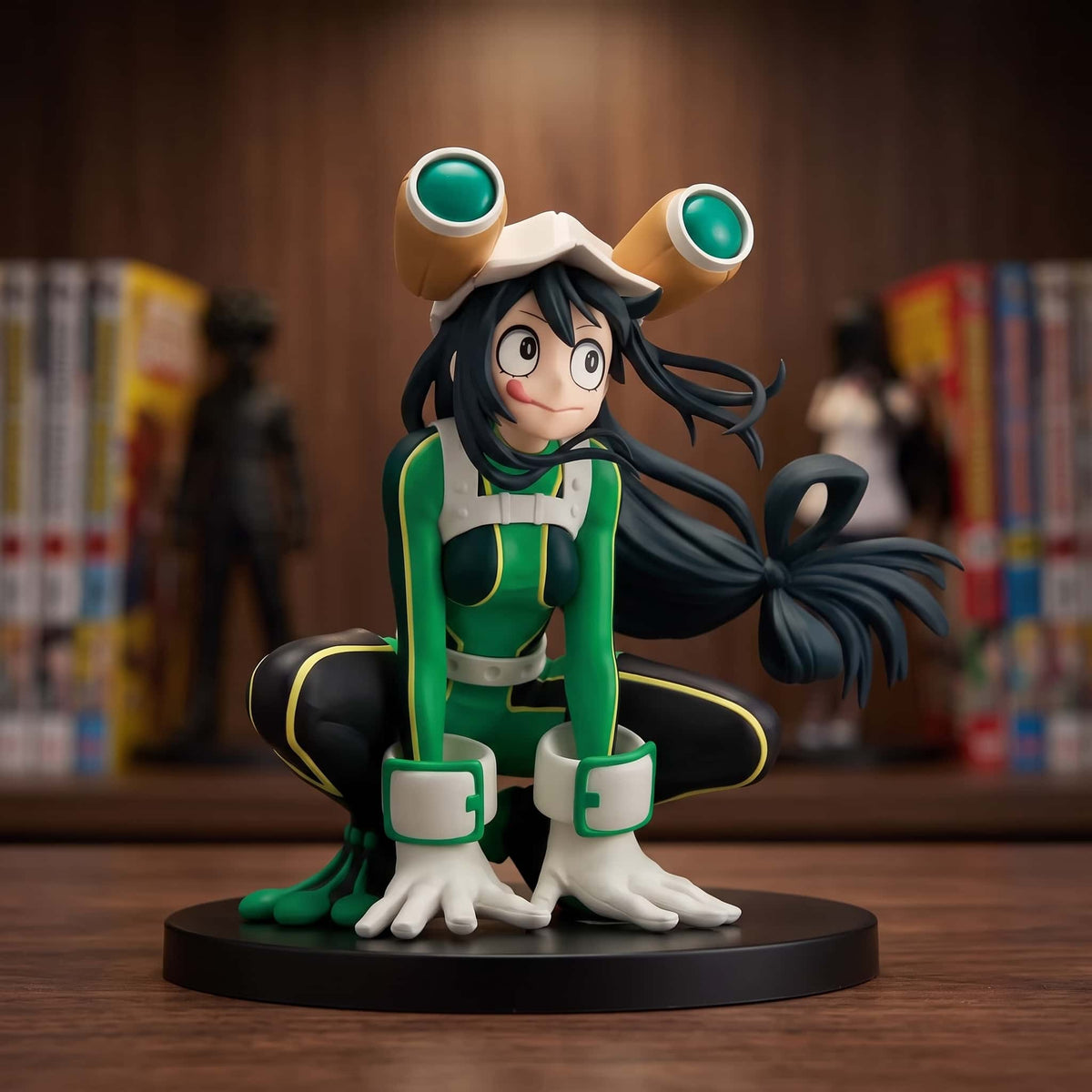 Figurine de Tsuyu Asui accroupie, casque à grands yeux verts et gants palmés posés au sol, combinaison verte et noire, 11 cm sur socle noir, posée sur une étagère en bois