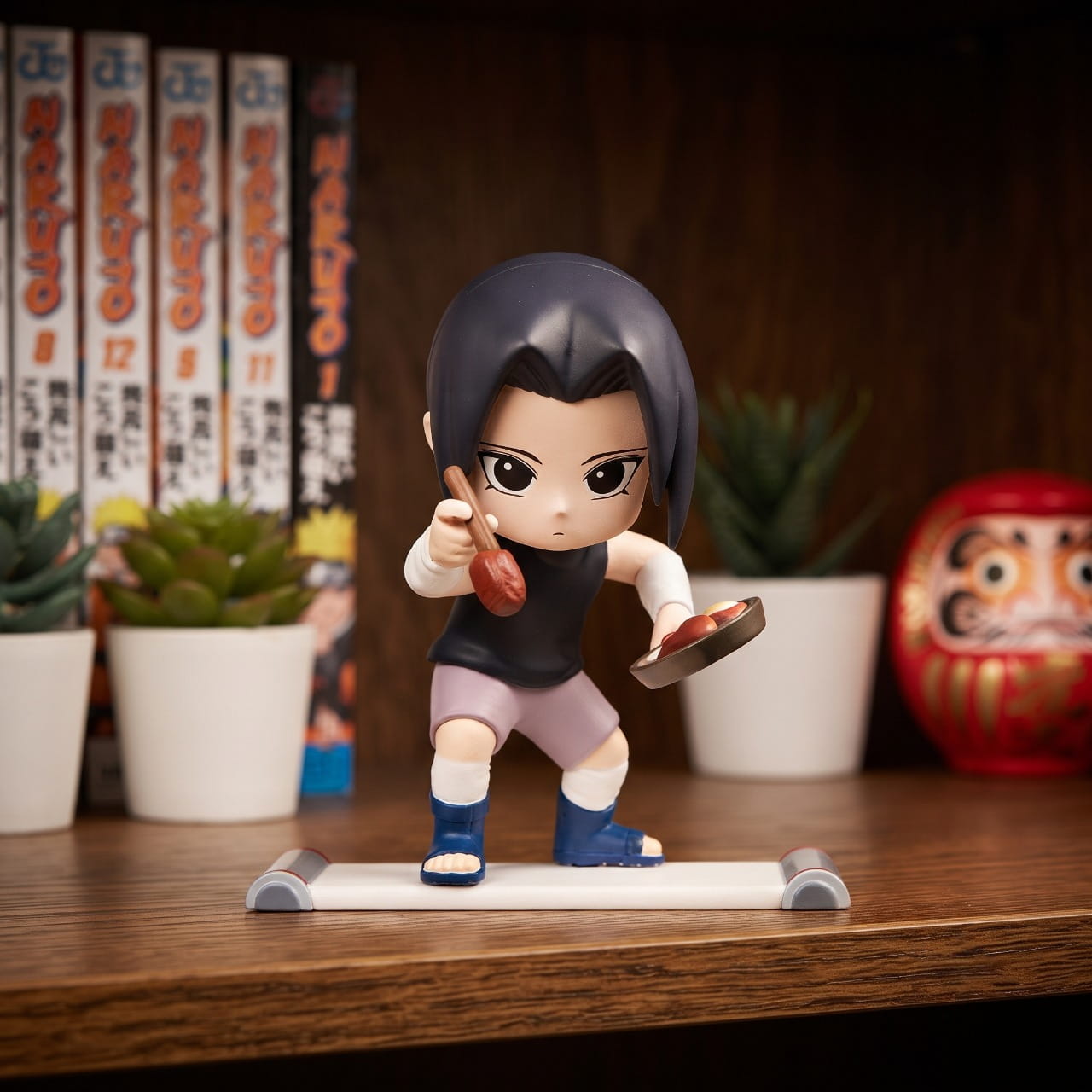 Figurine chibi Itachi Uchiha — poêle et cuillère en main, tenue sombre — Naruto, étagère (décor non inclus)