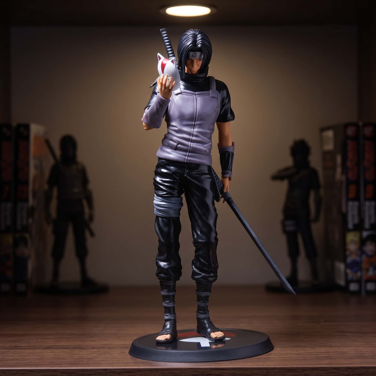 Figurine Itachi Uchiwa (Naruto), une pièce sobre : ni effet, ni socle décoré — posée sur une étagère en bois.