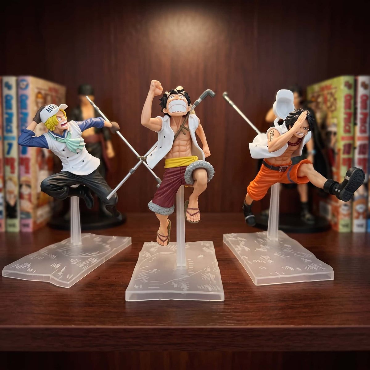 Figurines One Piece Luffy, Ace et Sabo en pleine course sur supports transparents, exposées sur une étagère (vendues à l'unité, décor non inclus)