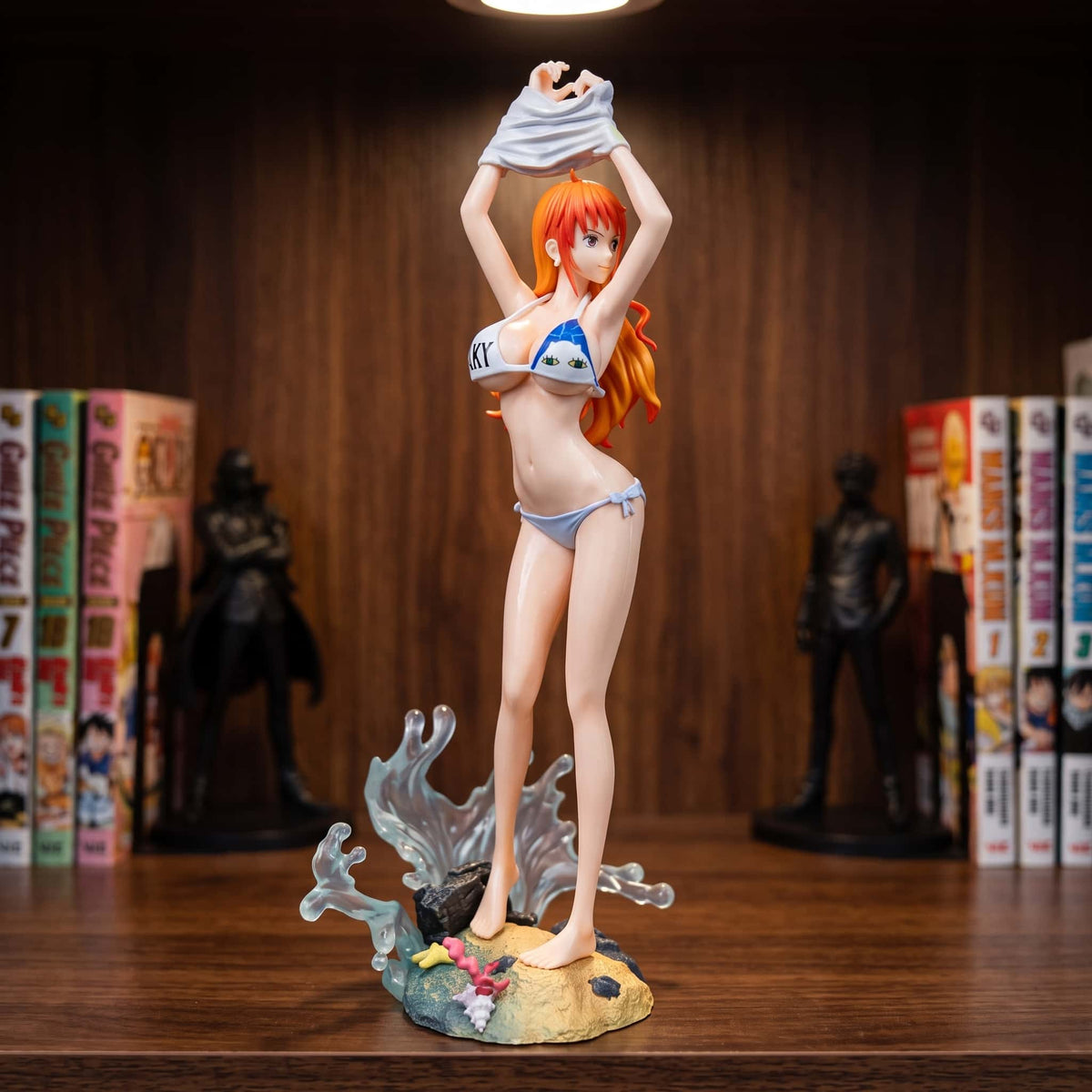 Figurine Nami One Piece 25 cm en bikini, t-shirt blanc relevé au-dessus de la tête, sur socle de plage, exposée sur une étagère (décor non inclus)
