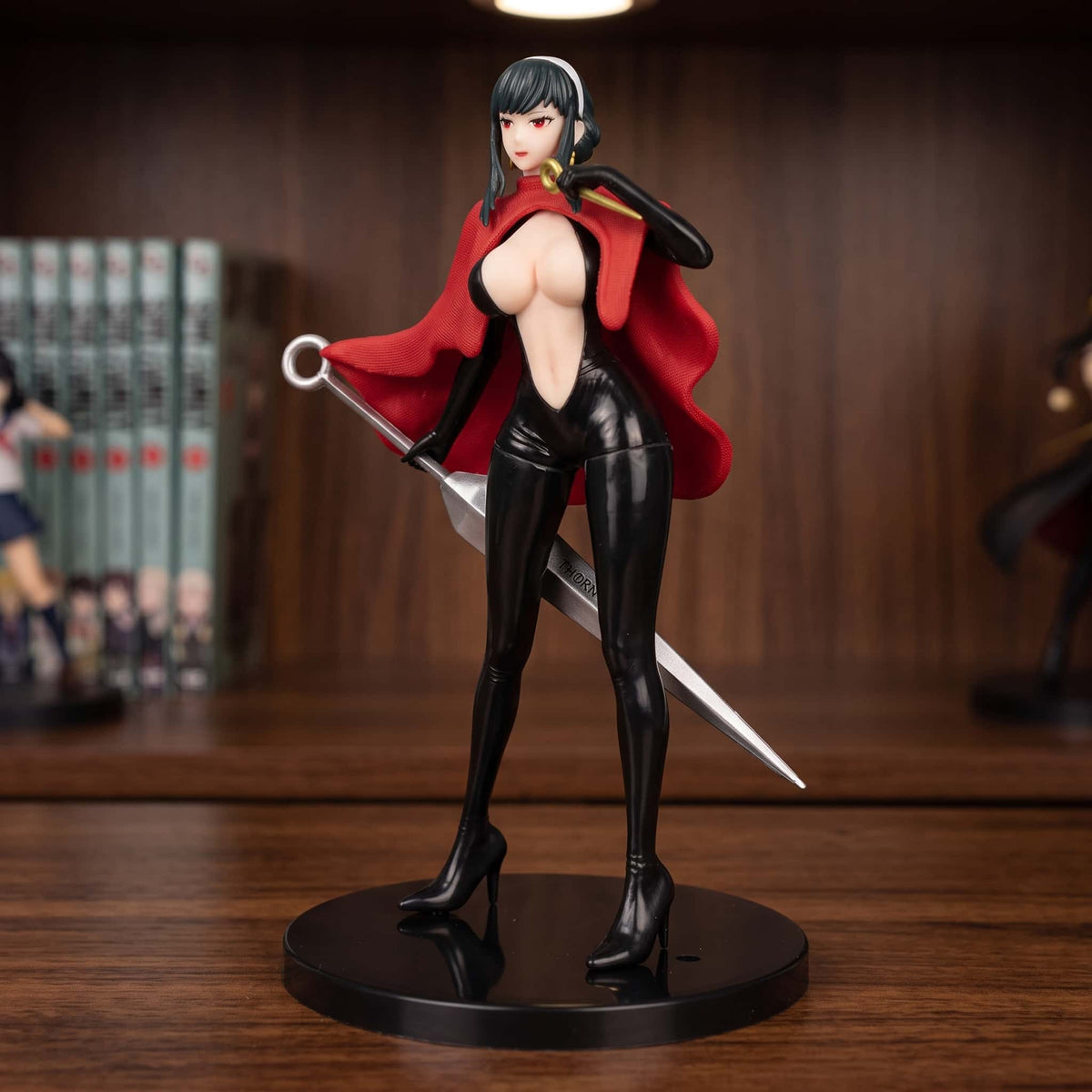 Figurine Yor Forger Spy x Family 23 cm en combinaison noire et cape rouge, lame argentée en main, exposée sur une étagère (décor non inclus)