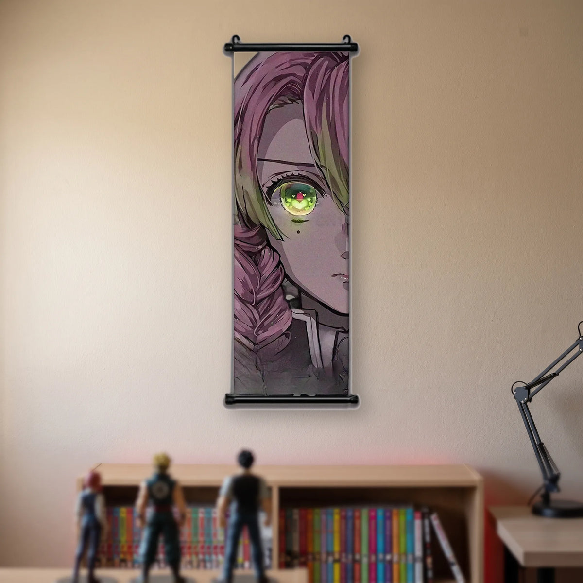 Kakémono Demon Slayer Mitsuri Kanroji en gros plan, tresse rose et verte et œil vert, suspendu au mur beige d'une chambre au-dessus d'une étagère de tomes de manga