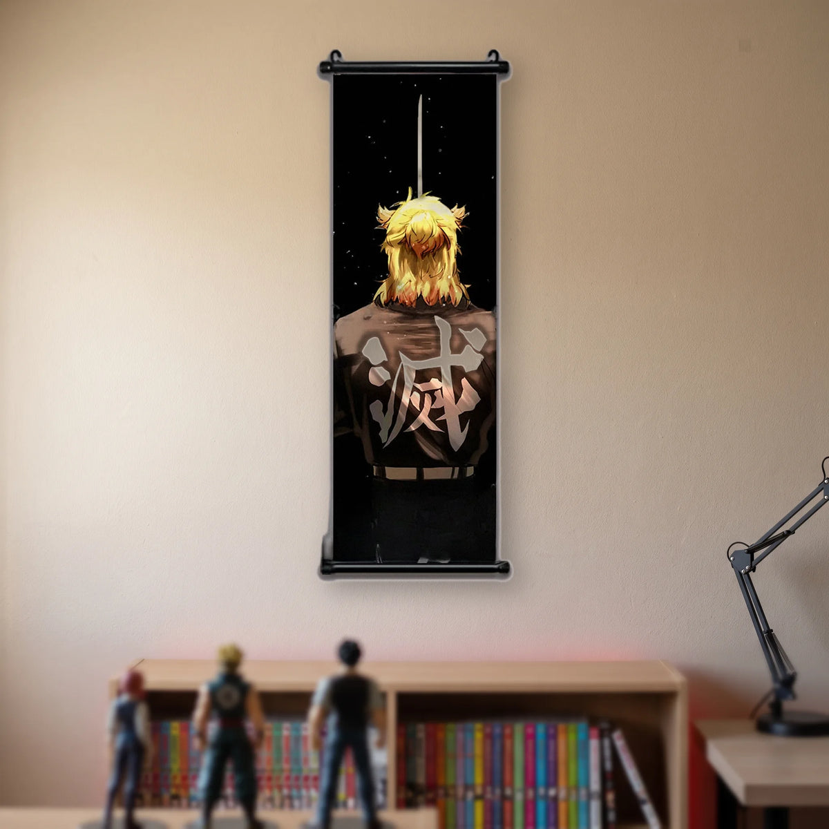 Kakémono Demon Slayer Kyojuro Rengoku de dos, chevelure de flammes et lame dressée, suspendu au mur beige d'une chambre au-dessus d'une étagère de tomes de manga