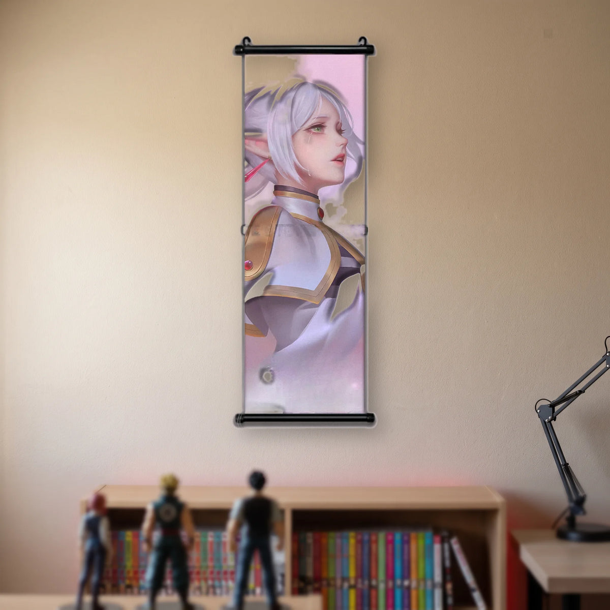 Kakémono Frieren, Frieren de profil, une larme sur la joue, sur un fond rose pâle, suspendu au mur beige d'une chambre au-dessus d'une étagère de tomes de manga