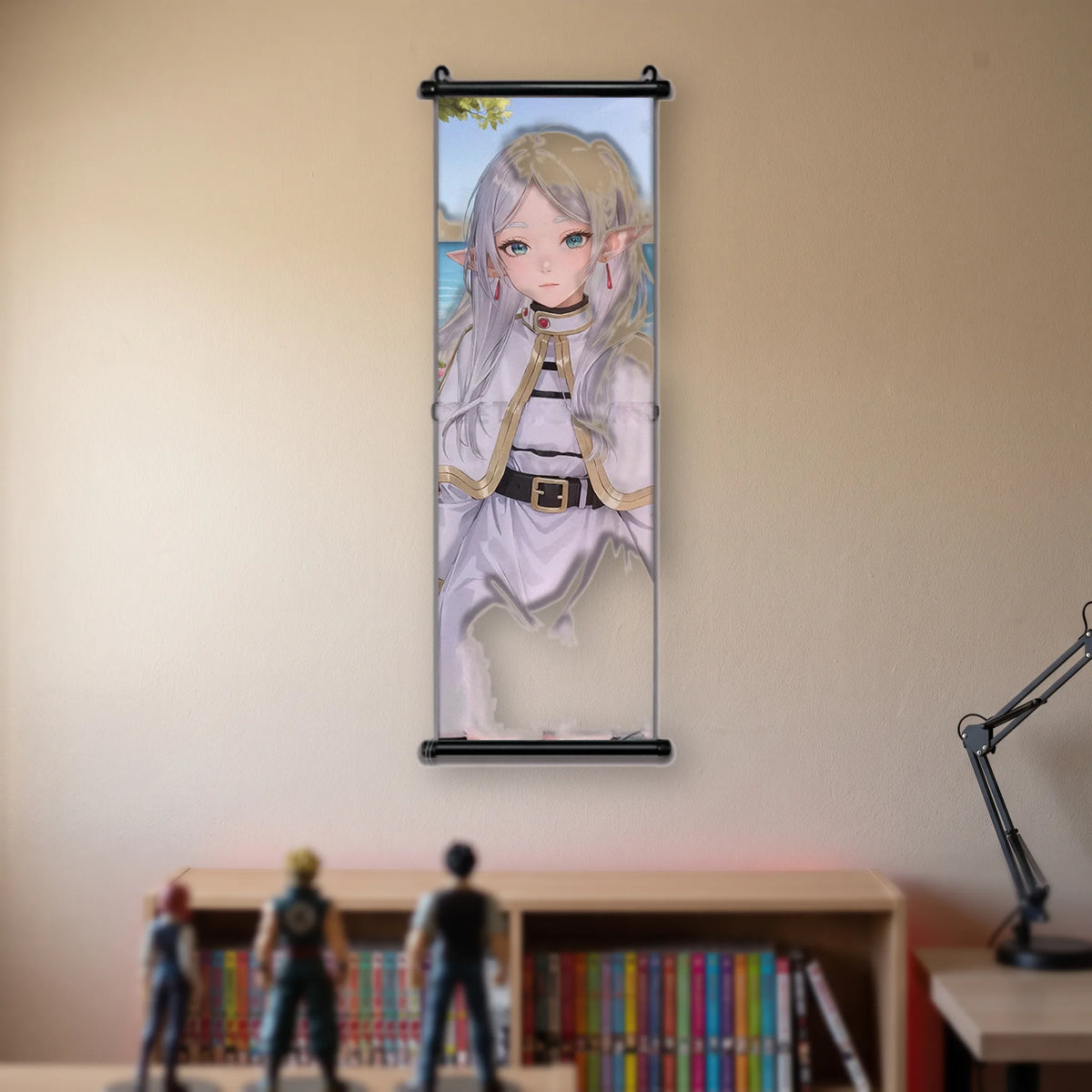 Kakémono Frieren, Frieren de face, portrait en pied, tenue blanche et ceinture de cuir, suspendu au mur beige d'une chambre au-dessus d'une étagère de tomes de manga