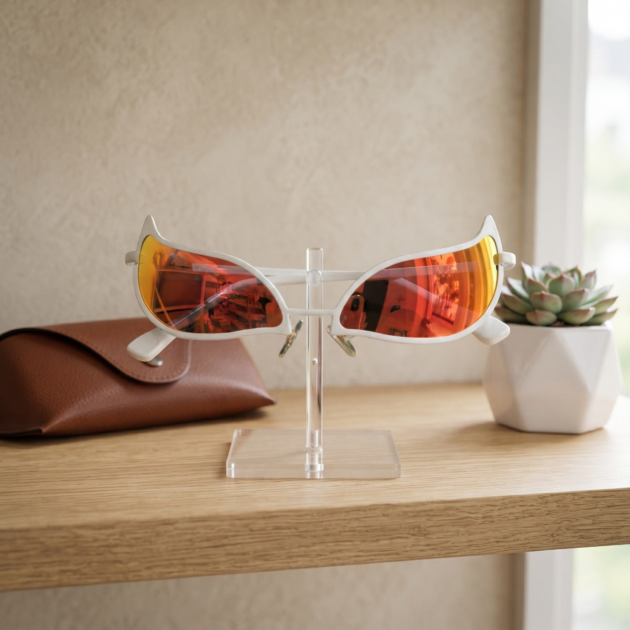 Lunettes One Piece Doflamingo à verres orange posées sur un présentoir en acrylique