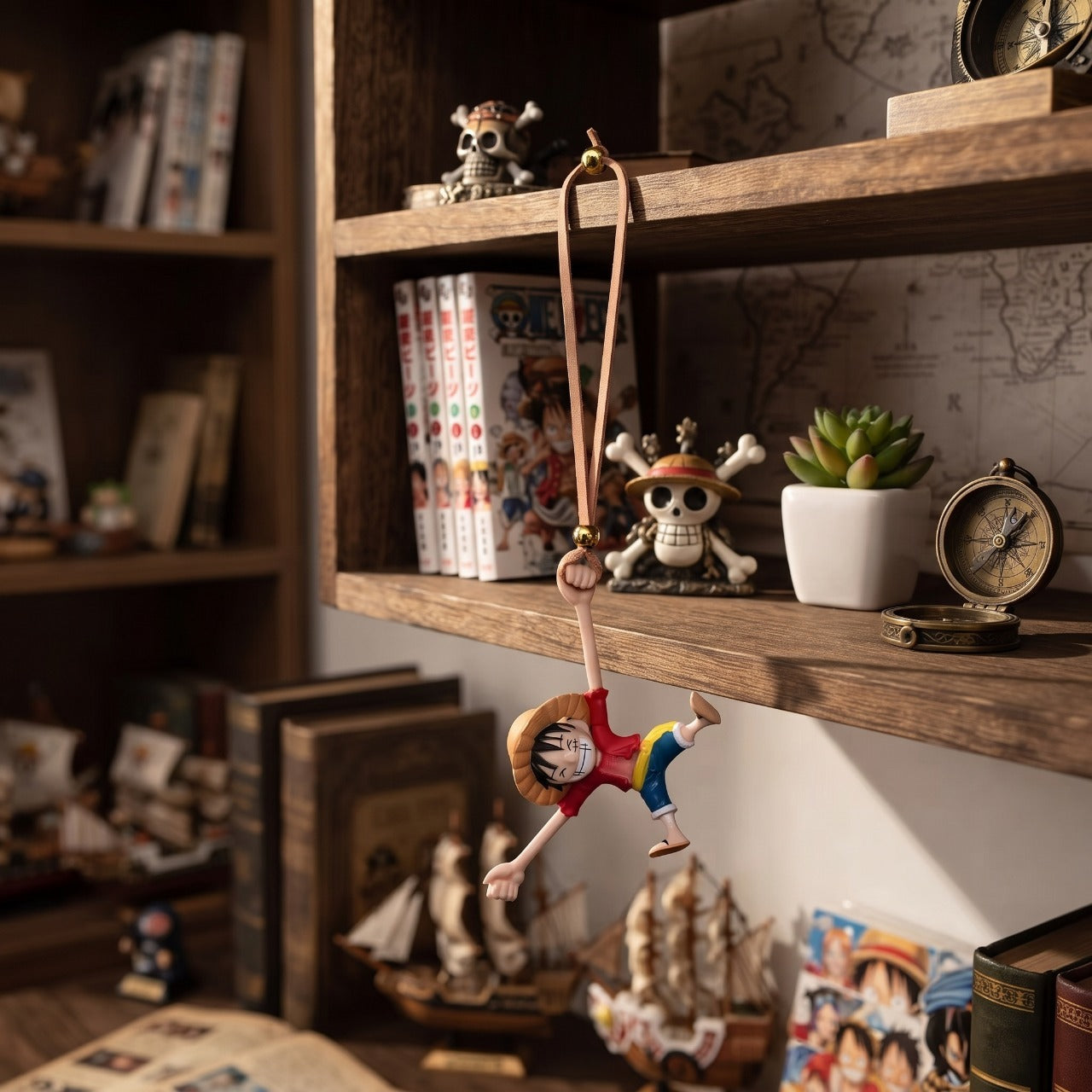 Pendentif One Piece Luffy suspendu devant une étagère garnie de figurines