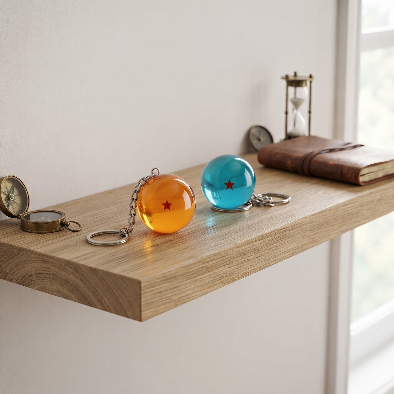 Deux porte-clés Dragon Ball, boules orange et bleue, posés sur une étagère en bois clair