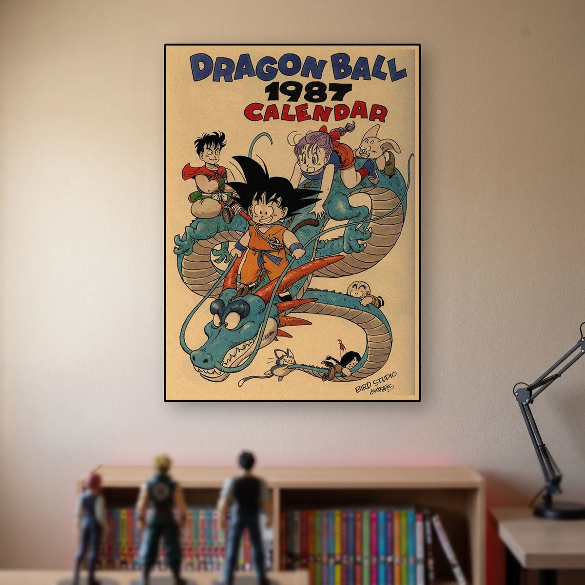 Poster Dragon Ball Goku enfant, Shenron — calendrier 1987, accroché sans cadre sur le mur beige d'une chambre, au-dessus d'une étagère de tomes de manga et de figurines